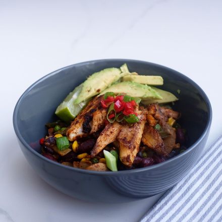 Close-up with unfocused background of a vibrant large blue butterfly gracefully perched on a delicate flower amidst lush green gras